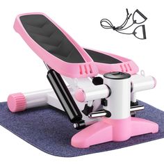 a pink and white machine on top of a blue mat next to a pair of glasses