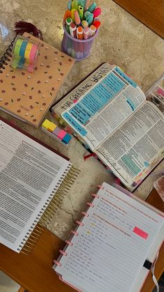 an open book sitting on top of a wooden table next to a cup filled with candy