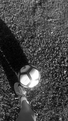 a person standing in the grass with a frisbee on their feet and shadow