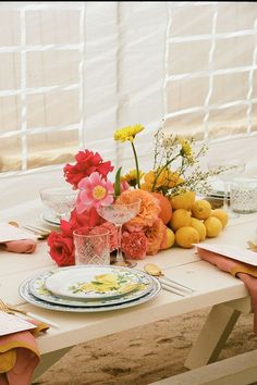 the table is set with flowers and plates