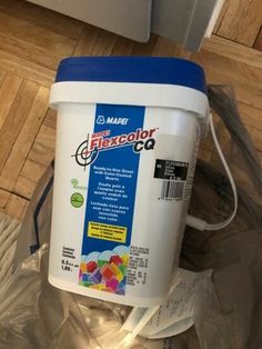 a bucket of paint sitting on top of a plastic bag