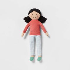 a doll with black hair and blue pants is laying on the floor, it looks like she's smiling