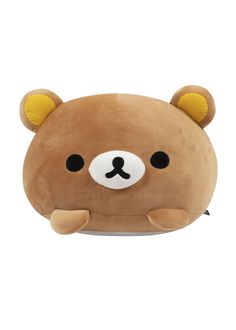 a brown teddy bear pillow sitting on top of a white floor