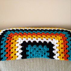 a crocheted blanket sitting on top of a couch