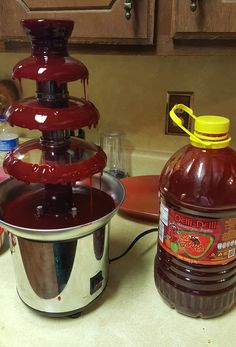 a bottle of liquid sitting on top of a counter next to a pot