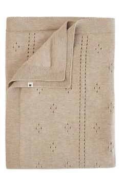 a beige blanket with holes on it