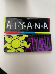 two wooden signs that say, ajyana and amana on them sitting on a table