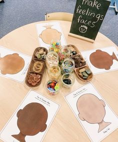 a wooden table topped with lots of cut out shapes and cards on top of it