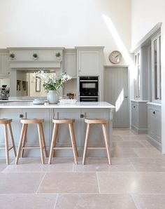 a kitchen with two stools and a center island in the middle of the room