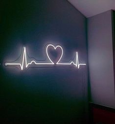 a neon sign that says i love you with a heart on the wall behind it