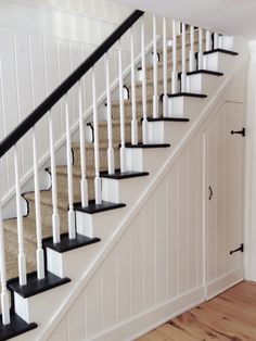 a staircase with black and white railings in a home's entryway area