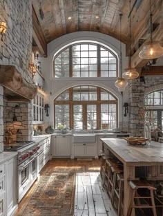 a large kitchen with an arched window and wooden floors