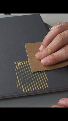 a hand is touching a piece of paper on top of a laptop computer that's being taped to the cover