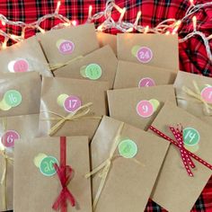 brown paper bags with numbers and ribbons tied around them on a plaid cloth covered tablecloth