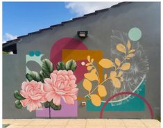 a large mural on the side of a building with flowers painted on it's sides