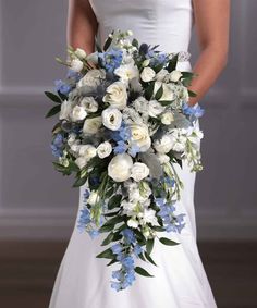 a bride holding a bouquet of white and blue flowers