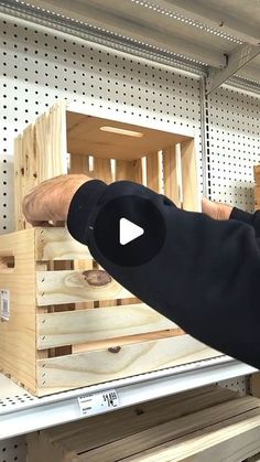 a man is pointing at some wooden crates on the shelves in a store or shop