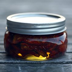 a jar filled with pickles sitting on top of a wooden table