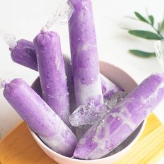 purple candles are in a bowl with ice