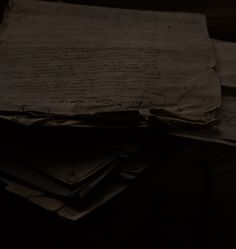 a pile of papers sitting on top of a wooden table