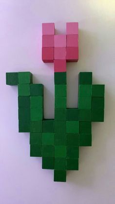 a piece of paper made to look like a green and pink plant with blocks on it