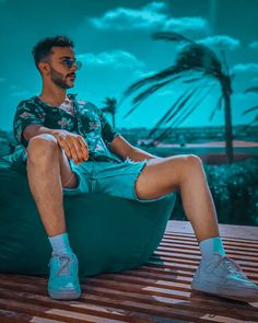 a man sitting on a bean bag chair with his legs crossed and wearing blue socks