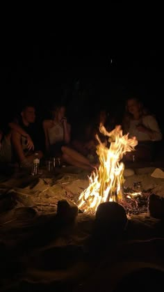 people sitting around a campfire at night