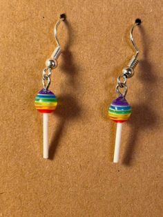 a pair of earrings that are made out of candy canes and rainbow colored beads