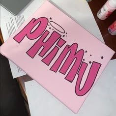 a pink sign that says primau on it sitting on top of a desk next to some papers