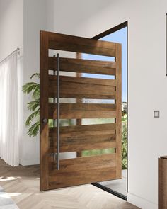 an open wooden door in a white room with wood flooring and large plant on the side