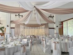 the banquet hall is decorated with white and pink linens