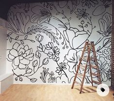 a ladder is standing in front of a floral wall mural