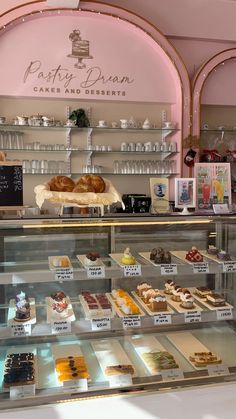 a pastry display in a bakery filled with pastries and desserts