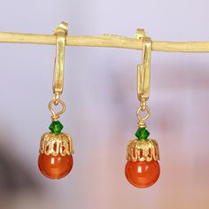 Mexican artisan Alejandra Aceves combines gorgeous jewels in a distinguished creation ideal to complement several ensembles. Ornamented with a high polish finish, these 14k gold-plated dangle earrings feature a luxurious, warm light in each detail. On top of that, natural carnelian beads and green Swarovski crystals complement the accessories' vibe, whose color combination allows for a glamorous look. Jewelry Workshop, Crystal Dangle Earrings, Carnelian Beads, Gold Jewelry Necklace, Jewelry Packaging, Jewelry Creation, Jewelry Necklace, Jewelry Gift Box, Color Combination