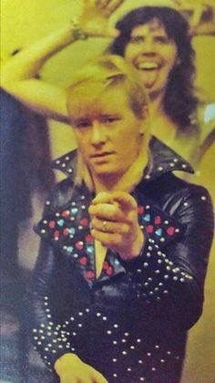 an old photo of a man with blonde hair wearing a leather jacket and holding his hand on his hip