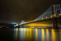 the bay bridge is lit up at night