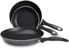 three black pans with handles and spoons