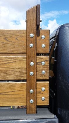 a wooden bench with metal rivets on it's sides and the back door open