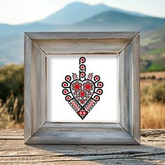 a wooden frame with a painting in the shape of a heart on top of it