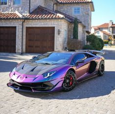 a purple and black sports car parked in front of a house