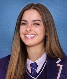 a young woman wearing a purple blazer and tie smiling at the camera with long hair