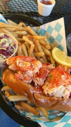 lobster sandwich with fries and coleslaw on the side