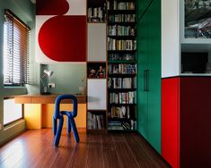 a chair sitting in front of a bookshelf filled with lots of books on top of a hard wood floor