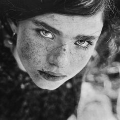 a woman with freckles on her face looking at the camera