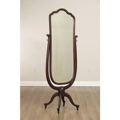 an antique wooden mirror on top of a stand