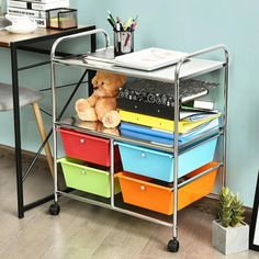 a teddy bear sitting on top of a metal cart filled with books and folders