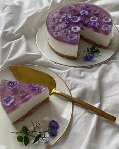 two slices of cheesecake with purple flowers on plates