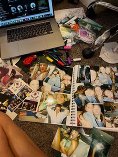 an open laptop computer sitting on top of a desk next to pictures and other items