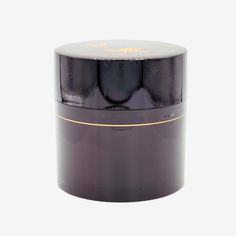 the container is black with gold trimmings on it and sits in front of a white background