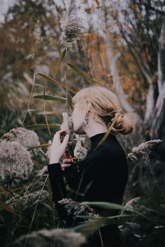 a woman standing in the middle of tall grass